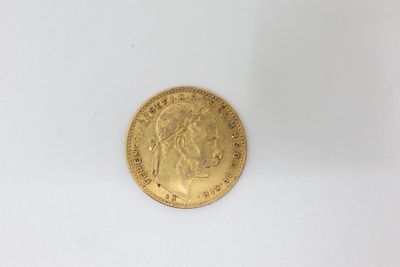 a close up of a gold coin on a white surface