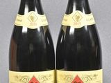 two bottles of red wine sitting next to each other on a table