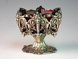 a silver bowl with a red glass inside of it
