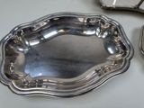 two silver trays on a table with a mirror in the background