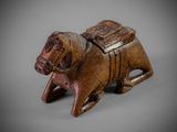 an old wooden figurine of a dog with a saddle