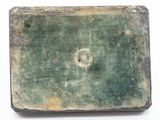 a green and black tile with a hole in the middle