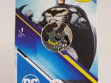 a close up of a batman coin on a stand on a white background