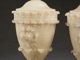 pair of carved ivory vases with flowers and leaves on the sides