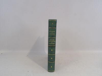 un livre vert posé sur une table blanche