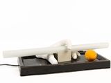 a white figurine sitting on top of a tray with an orange