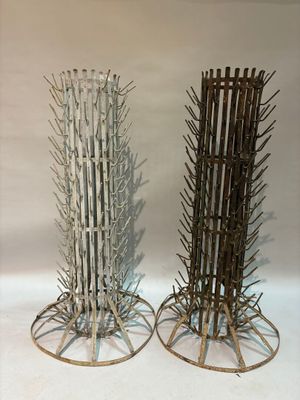 two tall wooden sticks are stacked on top of each other on a white surface