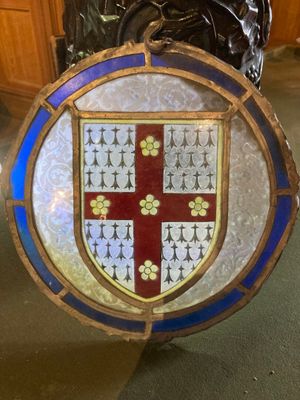 un blason en vitrail sur lequel figure un emblème