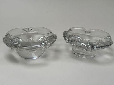 une paire de cendriers en verre transparent posés sur une surface blanche