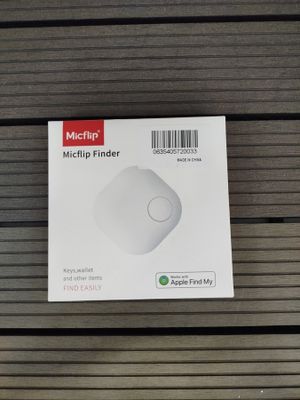 packaging of a white computer mouse sitting on top of a wooden table