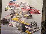 un homme tenant une grande affiche sur laquelle figurent plusieurs voitures de course