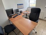 un bureau avec deux ordinateurs et une chaise dans un coin