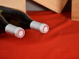three bottles of wine sitting on a red cloth