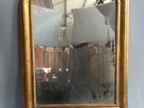 un miroir posé sur un support, lui-même posé sur une table