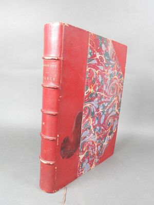 un vieux livre rouge posé sur une table à côté d'un mur blanc