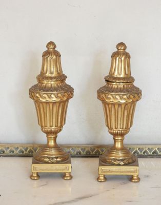 deux vases dorés posés sur une table en marbre