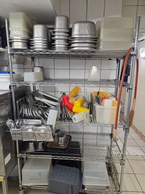 de nombreuses casseroles et poêles sur les étagères de la cuisine