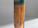 a blue and orange drink in a tall glass on a table