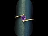 a close up of a ring with a purple stone on it