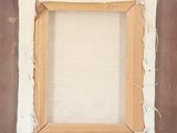an old picture frame with a piece of fabric hanging from it ' s side