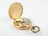 a gold pocket watch sitting on a white surface