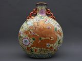 un vase orné d'un dragon posé sur une table
