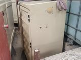 un réfrigérateur posé au milieu d'une pile de cartons