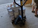 un homme debout à côté d'une charrette sur laquelle sont posés des seaux