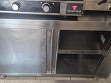 a stainless steel oven in a kitchen with a tile floor