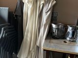 a table with a bunch of clothes on it and a chair in the background