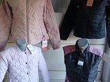 several jackets and jackets on display in a store window