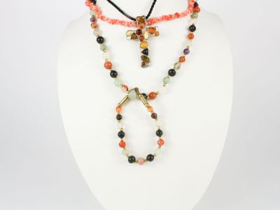 un ensemble composé d'un collier et d'un bracelet ornés de perles multicolores, présenté sur un mannequin