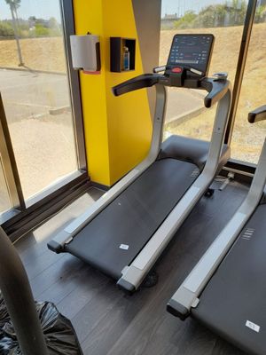 deux appareils de cardio dans une salle de sport avec vue depuis la fenêtre