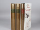 three books are stacked on top of each other on a table