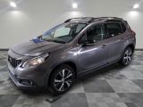 Le SUV Nissan gris est garé sur un sol en carrelage à damier.