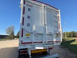 the back end of a white semi truck parked on the side of the road
