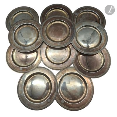 de nombreuses assiettes en argent posées sur une surface blanche