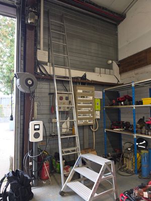 une photo d'un garage avec une échelle et un établi