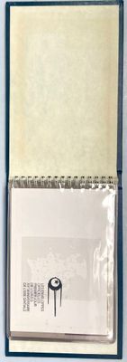 un bloc-notes avec un stylo à l'intérieur, posé sur une table