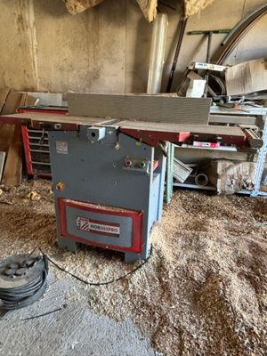 une photo d'un établi dans un garage avec une scie circulaire à table