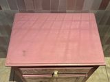 a small pink table with a drawer on top of it