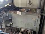 a metal cabinet in the middle of a room with a lot of clutter on it