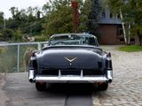 a black car parked on a cobblestone street