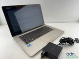 a laptop computer sitting on top of a table with a charger