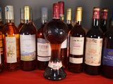 many bottles of wine sitting on a red table cloth