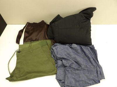 three pairs of pants and a bag sitting on a table