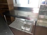 une étagère en métal sur laquelle est posé un panier, dans une cuisine