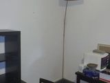 un bureau avec une lampe et une bibliothèque dans un coin