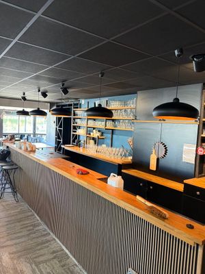 une photo d'un restaurant avec un bar et des chaises