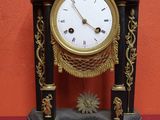 a black and gold clock on a red table